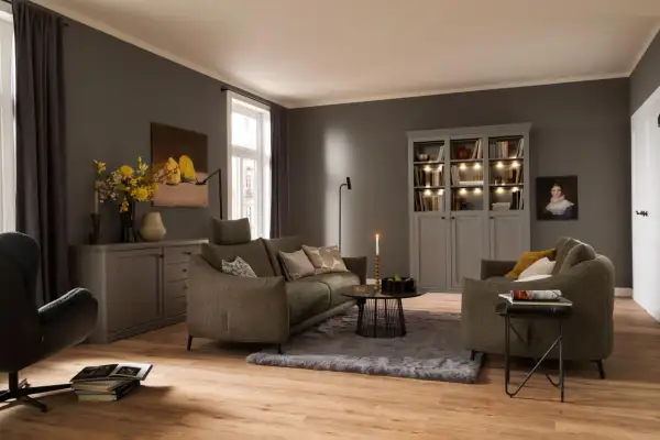 Ein weicher, grauer Teppich liegt unter dem Sofa und dem Couchtisch und schafft eine gemütliche Atmosphäre im Wohnzimmer.