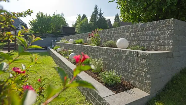 Moderne Gartenmauer mit Terrassierung und dekorativen Kugeln. Tolle Ideen für Gartenmauern, die Struktur und Stil verleihen.